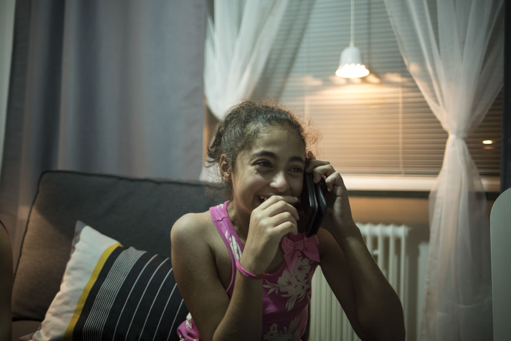 Sidra, la nièce d'Ahmad et Jihane annonce à sa mère restée en Syrie qu'elle vient d'arriver en Suède. Bromölla, Suède.19 juillet 2015.


