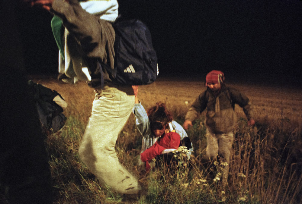 La famille tente de pénétrer dans la zone de fret du site d’Eurotunnel pour monter sur un train de marchandises. 
Coquelle septembre 2001.
